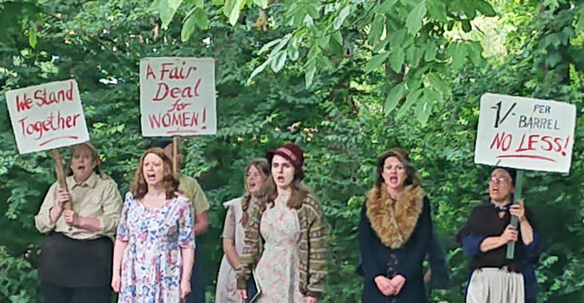 Women in period costume holding protest signs