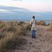 Back of a woman carrying a megaphone, looking out to sea