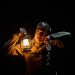 Man holding lamp in the dark listening to a watch