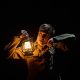 Man holding lamp in the dark listening to a watch